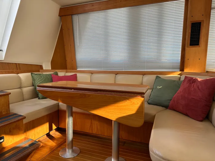  Yacht Photos Pics Cozy interior of 2000 Mainship 43 Trawler Aft Cabin with seating and wooden table.