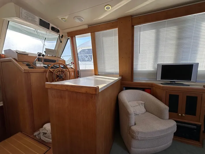  Yacht Photos Pics Interior of 2000 Mainship 43 Trawler Aft Cabin with helm, chair, and TV.