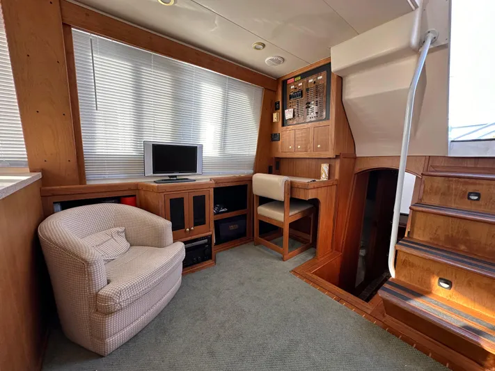  Yacht Photos Pics Mainship 43 Trawler Aft Cabin interior, featuring cozy seating, TV, and wooden cabinetry, 2000 model.