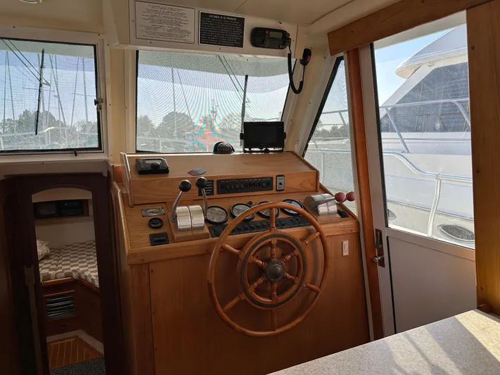  Yacht Photos Pics Mainship 43 Trawler Aft Cabin 2000 helm with wooden wheel and navigation instruments.