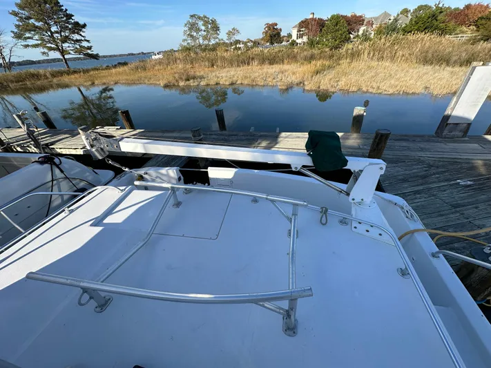  Yacht Photos Pics 2000 Mainship 43 Trawler Aft Cabin docked by a serene waterfront with trees.