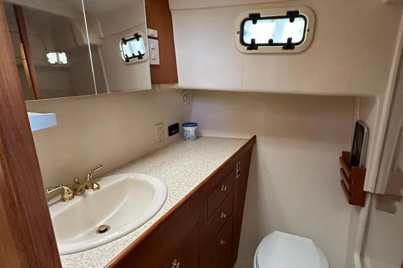  Yacht Photos Pics Bathroom in 2000 Mainship 43 Trawler Aft Cabin with sink, toilet, and storage cabinets.