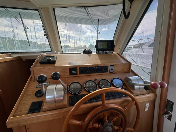 Yacht Photos Pics 2000 Mainship 43 Trawler Aft Cabin helm with wooden wheel and navigation instruments.