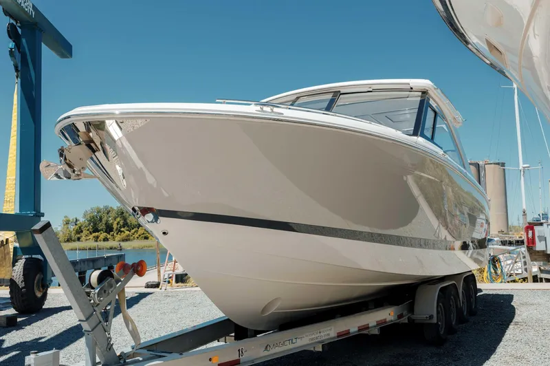  Yacht Photos Pics 2022 Regal LX36 boat on trailer, displayed outdoors under clear blue sky.