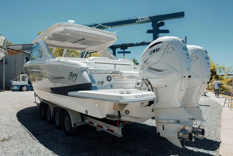  Yacht Photos Pics 2022 Regal LX36 boat with dual Yamaha engines on a trailer, parked outdoors.