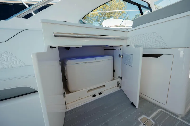  Yacht Photos Pics 2022 Regal LX36 boat interior with open storage compartment and cooler.