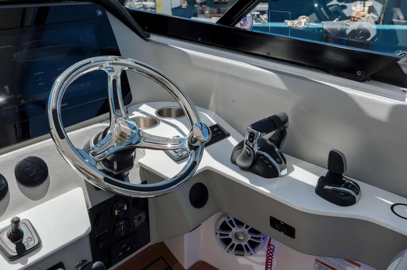  Yacht Photos Pics 2022 Regal LX36 boat helm with chrome steering wheel and control panel.