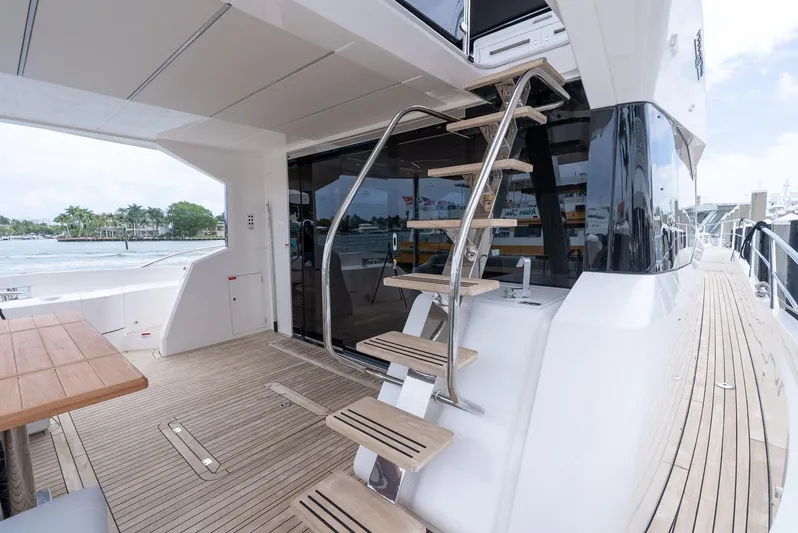  Yacht Photos Pics 2024 Sunseeker Manhattan 68 yacht deck with wooden flooring and sleek staircase.