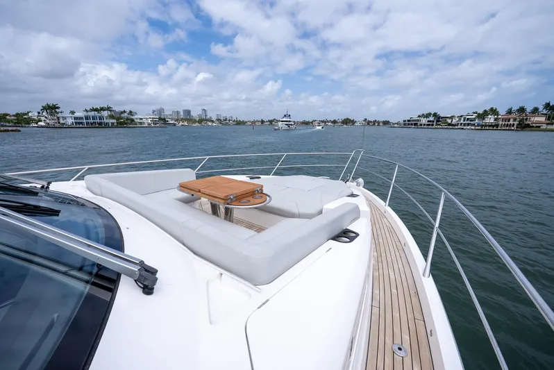  Yacht Photos Pics 2024 Sunseeker Manhattan 68 yacht with spacious deck and seating, cruising on a scenic waterway.