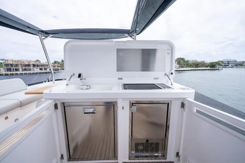  Yacht Photos Pics Outdoor kitchen on 2024 Sunseeker Manhattan 68 yacht, featuring grill and storage, with waterfront view.