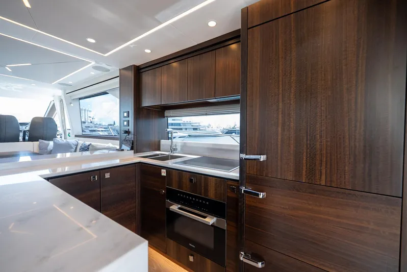  Yacht Photos Pics Luxurious kitchen interior of 2024 Sunseeker Manhattan 68 yacht with sleek wood cabinetry.