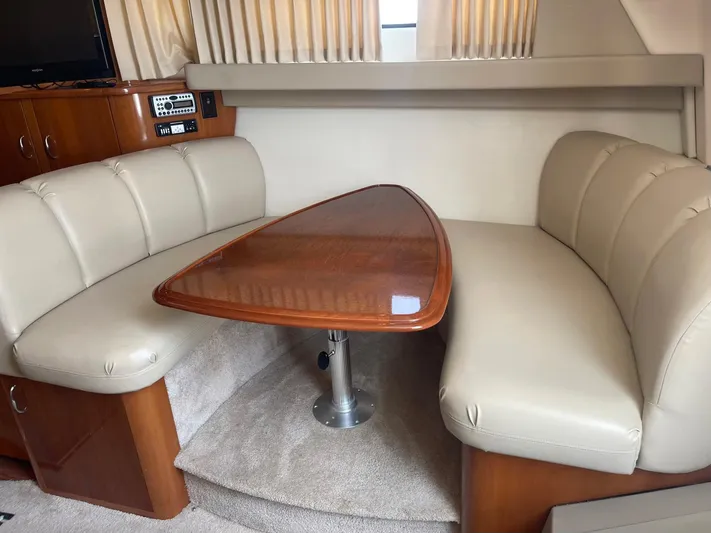 Andiamo Freedom Yacht Photos Pics Interior of 2006 Carver 36 Mariner with beige seating and wooden table.