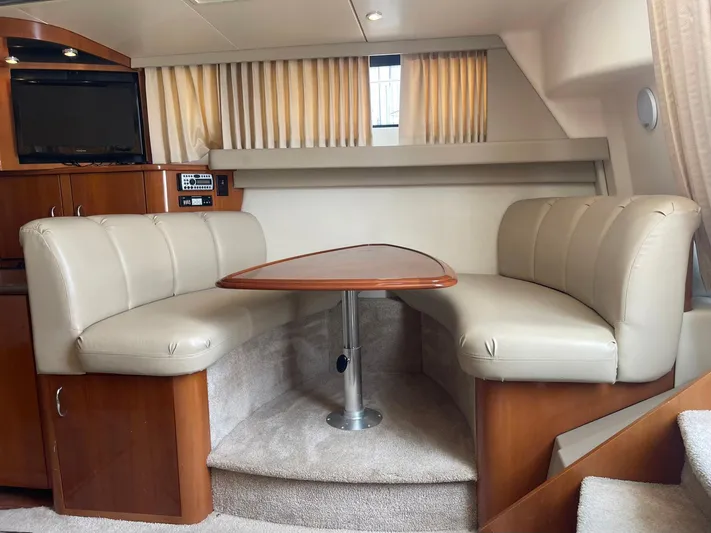 Andiamo Freedom Yacht Photos Pics 2006 Carver 36 Mariner interior with beige leather seating and wooden table.