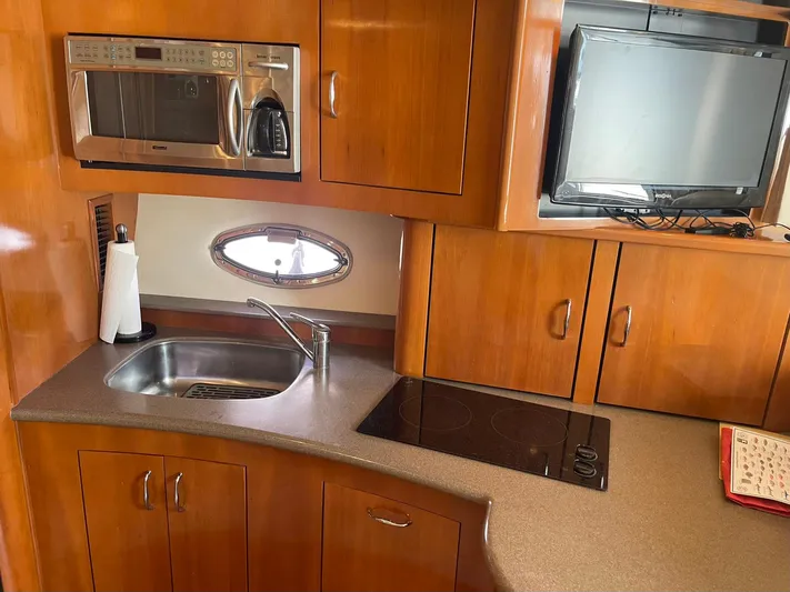 Andiamo Freedom Yacht Photos Pics 2006 Carver 36 Mariner kitchen with sink, stove, microwave, and TV.