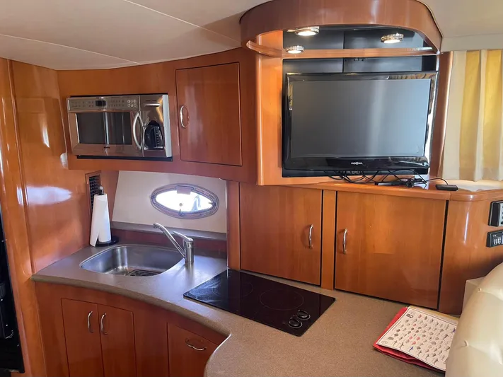 Andiamo Freedom Yacht Photos Pics 2006 Carver 36 Mariner interior with kitchenette, TV, and wooden cabinetry.