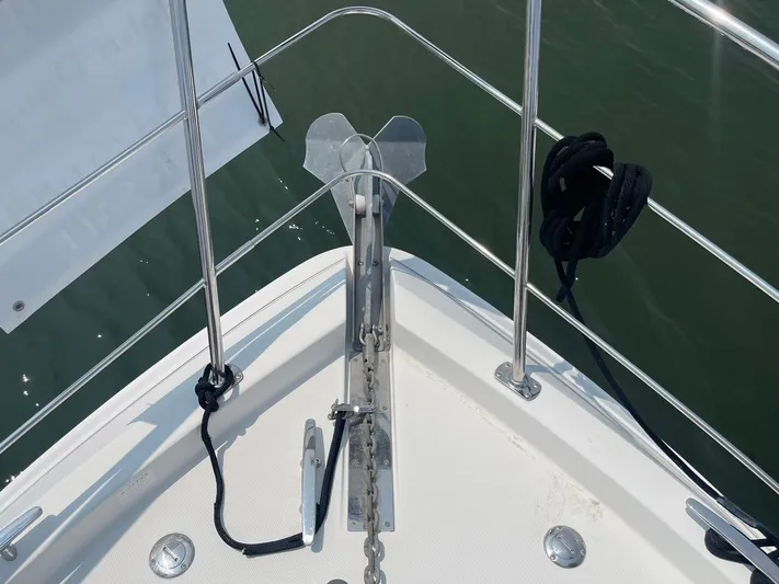 Andiamo Freedom Yacht Photos Pics Bow of 2006 Carver 36 Mariner with anchor and railing, docked on calm water.