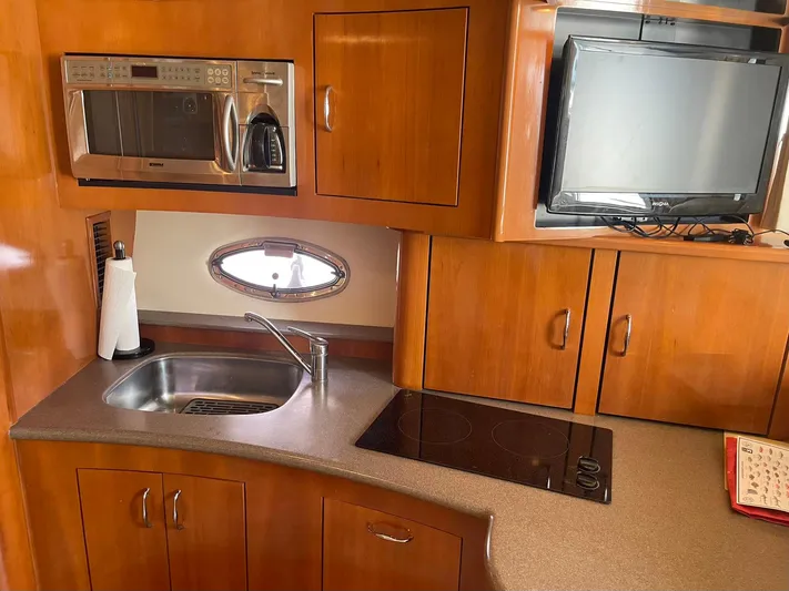 Andiamo Freedom Yacht Photos Pics 2006 Carver 36 Mariner kitchen with sink, microwave, stove, and TV.