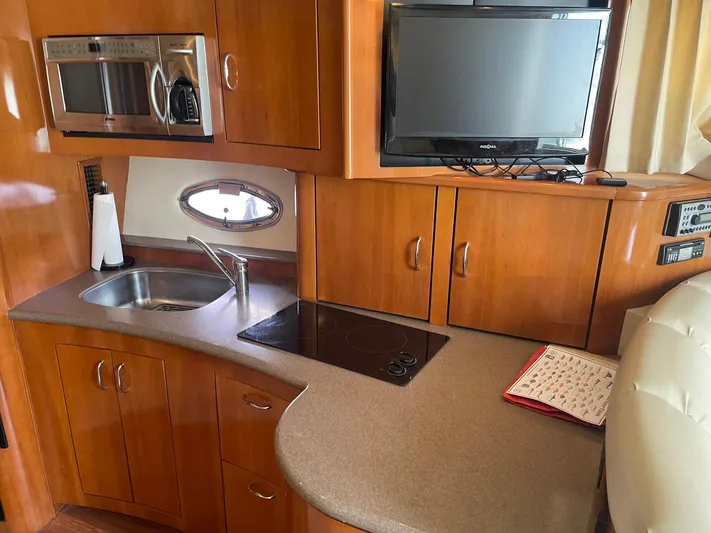 Andiamo Freedom Yacht Photos Pics 2006 Carver 36 Mariner kitchen with microwave, sink, stove, and TV.