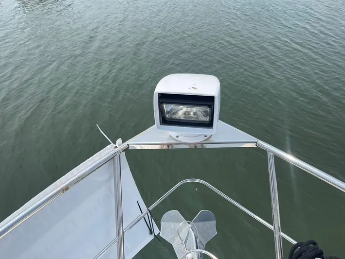 Andiamo Freedom Yacht Photos Pics Bow view of 2006 Carver 36 Mariner with spotlight and anchor over water.