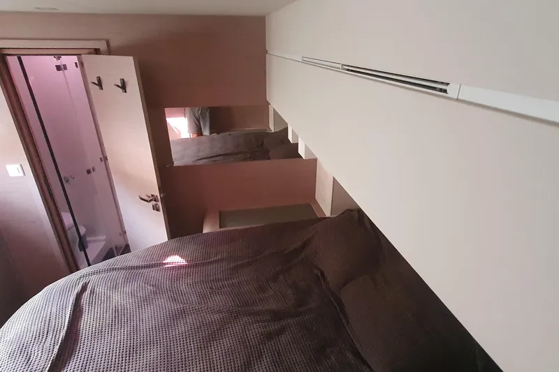  Yacht Photos Pics Interior cabin of 2023 Fountaine Pajot Samana 59 yacht, featuring cozy bed and ensuite bathroom.