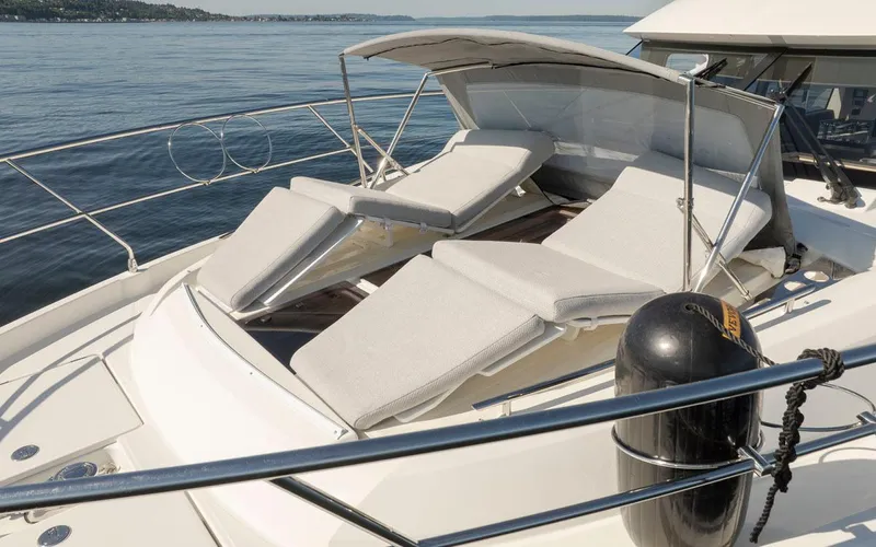 Four At Sea Yacht Photos Pics Luxury sun loungers on 2019 Prestige 460 yacht deck, overlooking serene waters.