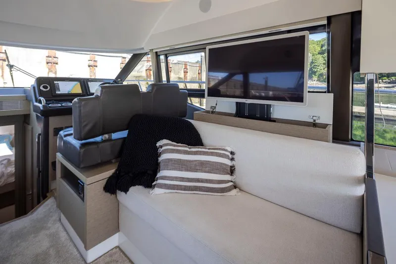 Four At Sea Yacht Photos Pics Luxurious interior of 2019 Prestige 460 yacht with sofa, TV, and helm station.
