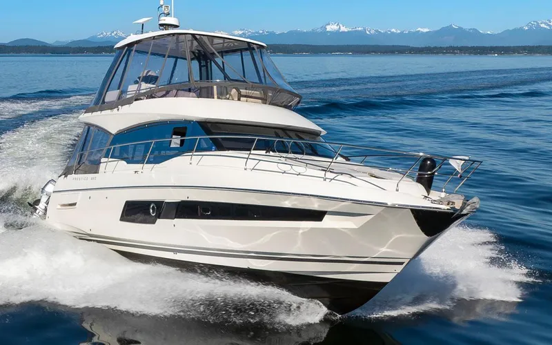 Four At Sea Yacht Photos Pics 2019 Prestige 460 yacht cruising on open water with mountains in the background.