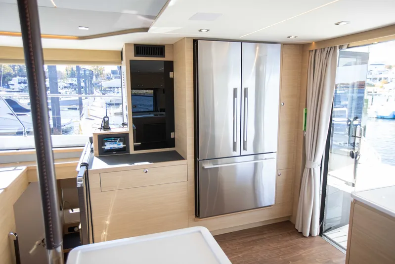  Yacht Photos Pics Modern kitchen interior of 2023 Aquila 54 Yacht with stainless steel appliances and large windows.
