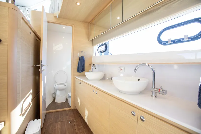  Yacht Photos Pics Luxurious bathroom interior of 2023 Aquila 54 Yacht with dual sinks and modern fixtures.