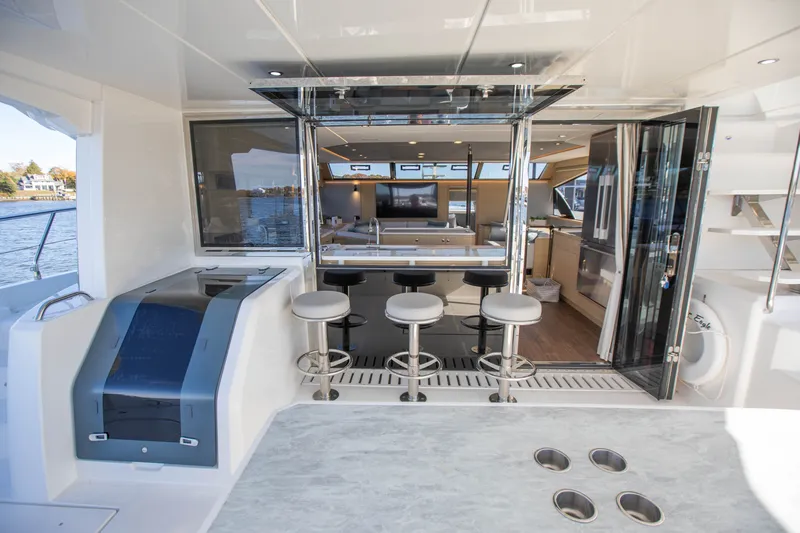  Yacht Photos Pics Luxurious 2023 Aquila 54 Yacht interior with bar stools and open kitchen area.