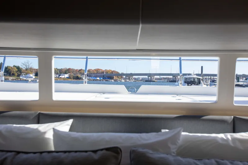  Yacht Photos Pics Interior view from 2023 Aquila 54 Yacht, showcasing marina and waterfront through large windows.