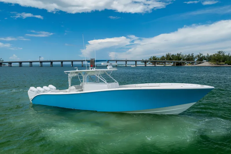  Yacht Photos Pics 2009 Yellowfin 42 Offshore boat on clear water with bridge and blue sky background.