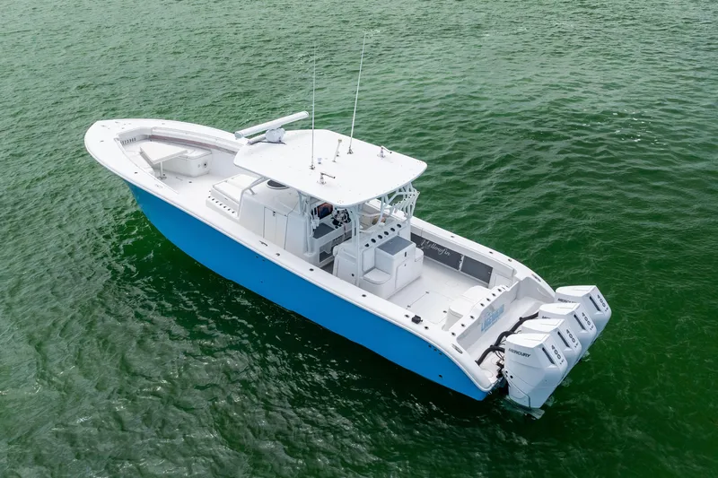  Yacht Photos Pics 2009 Yellowfin 42 Offshore boat with triple Mercury engines on green water.