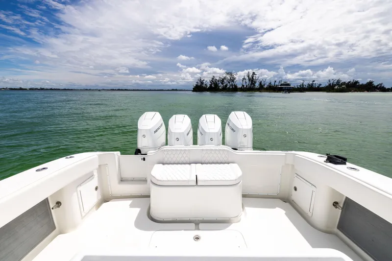  Yacht Photos Pics 2009 Yellowfin 42 Offshore boat with four engines on calm water under a cloudy sky.