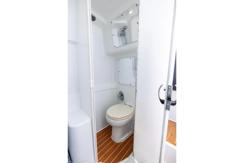  Yacht Photos Pics 2009 Yellowfin 42 Offshore boat bathroom with toilet and shower, featuring wood-style flooring.