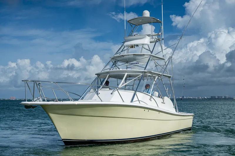  Yacht Photos Pics 2006 Topaz 32 Express boat cruising on the water under a blue sky.