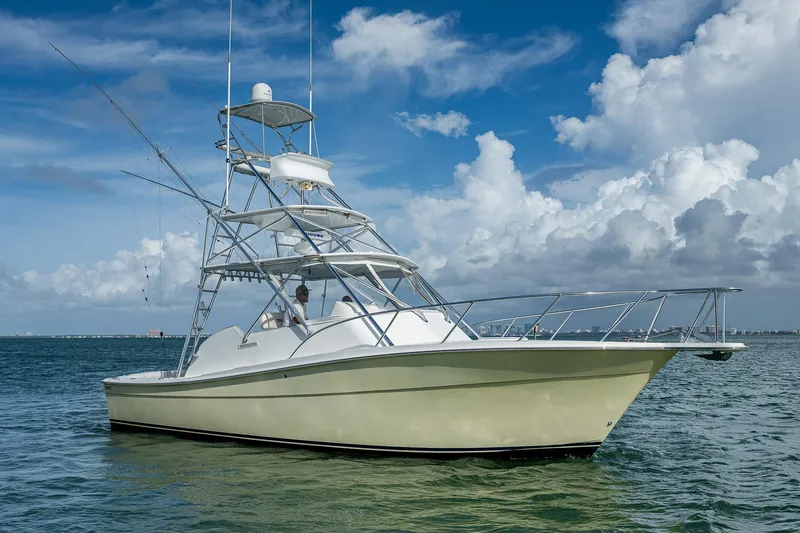  Yacht Photos Pics 2006 Topaz 32 Express boat on calm waters under a blue sky.