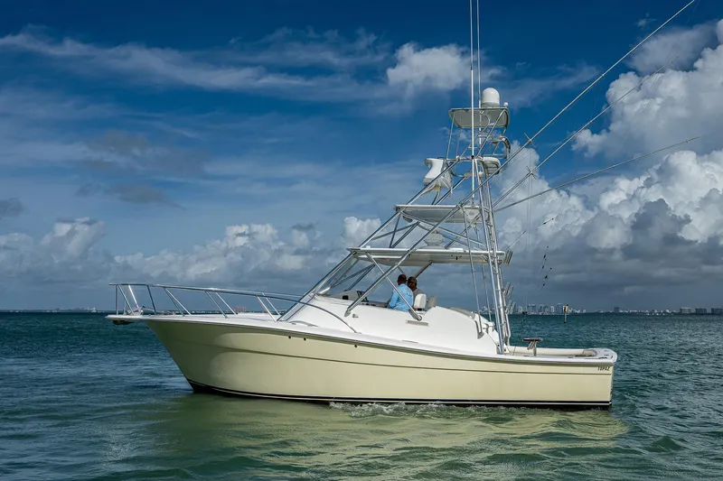  Yacht Photos Pics 2006 Topaz 32 Express boat on calm waters under a blue sky.