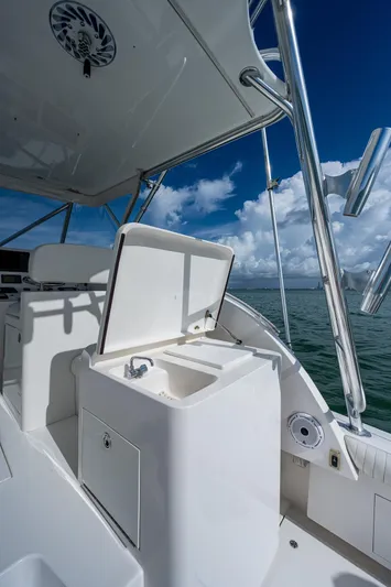  Yacht Photos Pics 2006 Topaz 32 Express boat with open storage compartment on deck.