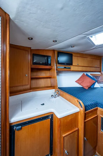  Yacht Photos Pics 2006 Topaz 32 Express cabin interior with kitchenette and bed.