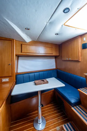  Yacht Photos Pics 2006 Topaz 32 Express boat interior with dining area and wooden cabinetry.