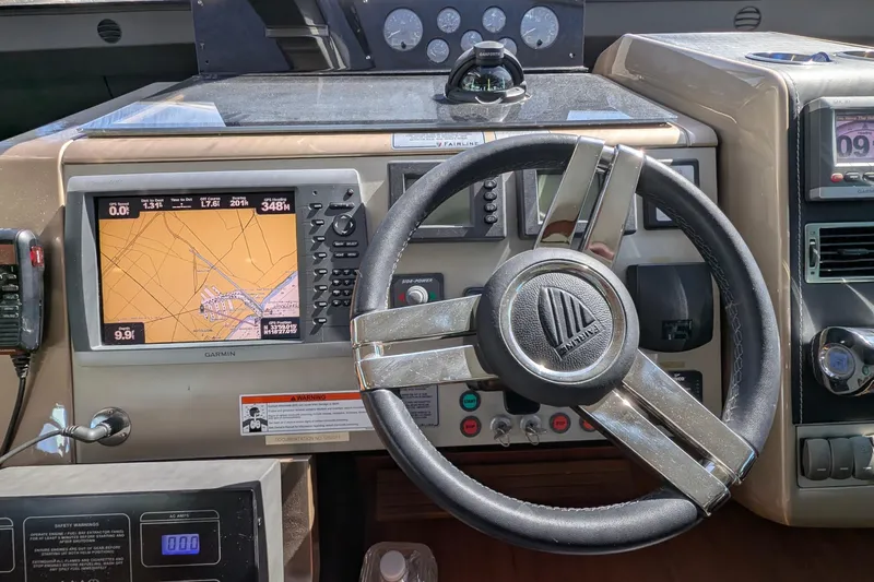 Casa Amigos Yacht Photos Pics Steering wheel and navigation system of 2010 Fairline Squadron yacht cockpit.