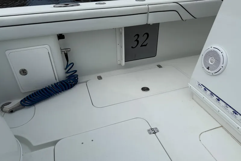  Yacht Photos Pics 2015 Yellowfin 32 boat deck with storage, coiled hose, and speaker.