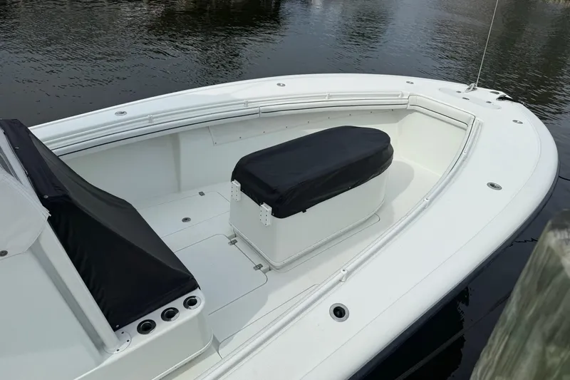  Yacht Photos Pics 2015 Yellowfin 32 boat with covered seating, docked on calm water.