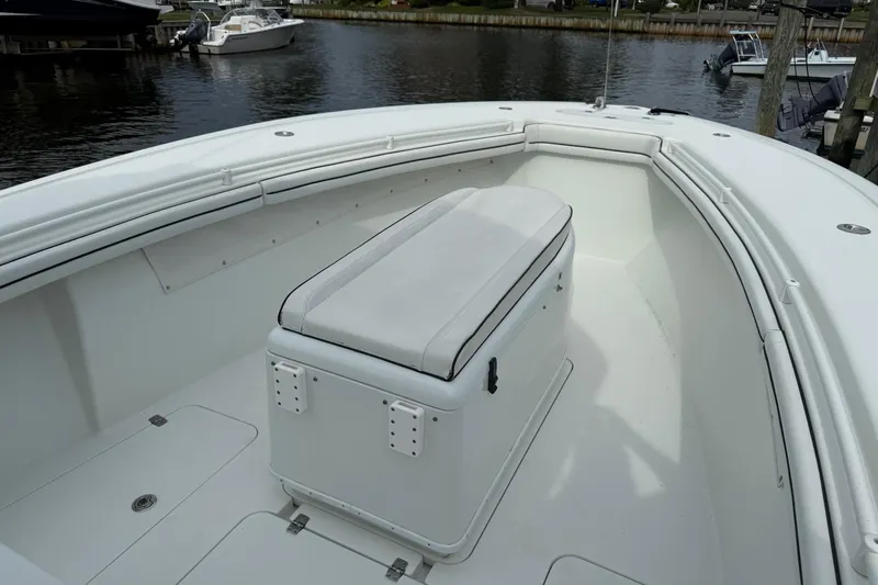  Yacht Photos Pics 2015 Yellowfin 32 boat interior with white seating and storage, docked by the water.
