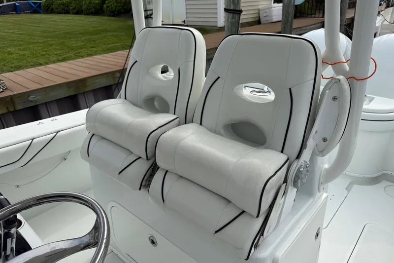  Yacht Photos Pics 2015 Yellowfin 32 boat interior with white cushioned seats and steering wheel.