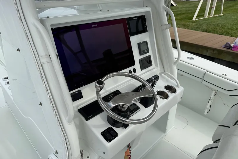  Yacht Photos Pics Center console of a 2015 Yellowfin 32 boat with steering wheel and navigation display.