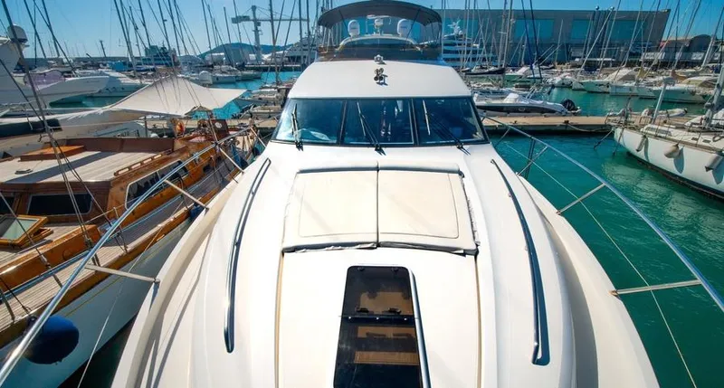  Yacht Photos Pics 2010 Princess 62 Flybridge yacht docked in a marina, surrounded by other boats.
