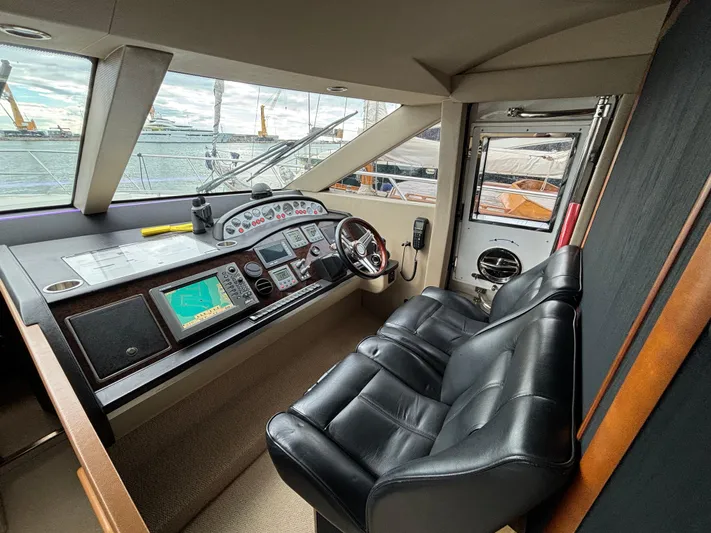  Yacht Photos Pics Helm of 2010 Princess 62 Flybridge yacht with leather seats and navigation equipment.