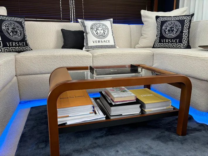  Yacht Photos Pics Luxurious yacht interior with Versace pillows, glass coffee table, and ambient blue lighting.
